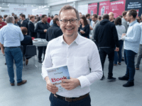 Author promoting a book at a lively book fair.